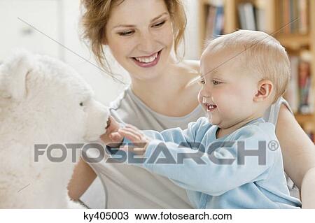 Baby girl playing with a teddy bear and laughing View Large Photo Image Stock Image - Baby girl playing with a teddy bear and laughing. Fotosearch