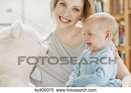 Baby girl playing with a teddy bear and smiling View Large Photo Image Stock Image - Baby girl playing with a teddy bear and smiling. Fotosearch