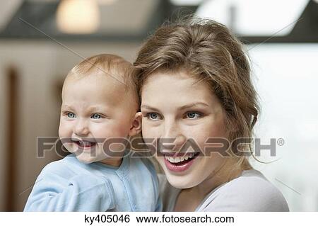 Stock Photograph - Close-up of a women smiling with her baby girl. Fotosearch