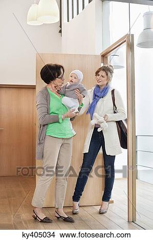 Nanny carrying a baby View Large Photo Image Picture - Nanny carrying a baby. Fotosearch
