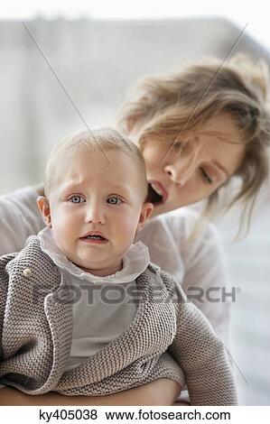 Woman consoling her crying baby View Large Photo Image Stock Photo - Woman consoling her crying baby. Fotosearch