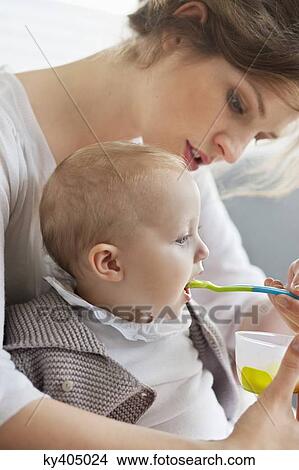 Woman feeding her daughter View Large Photo Image Picture - Woman feeding her daughter. Fotosearch
