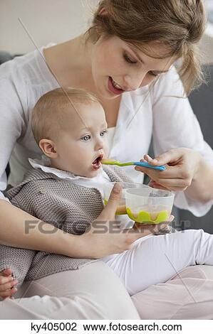Woman feeding her daughter View Large Photo Image Stock Image - Woman feeding her daughter. Fotosearch
