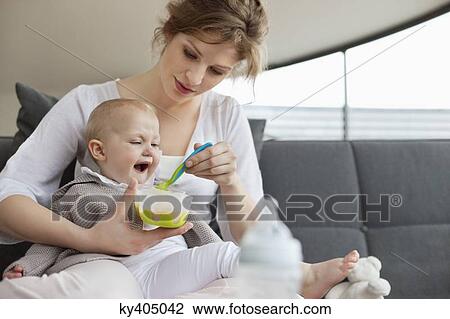 Woman feeding her daughter View Large Photo Image Stock Image - Woman feeding her daughter. Fotosearch
