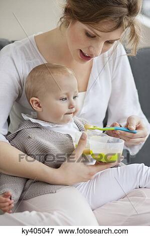 Stock Photo - Woman feeding her daughter. Fotosearch