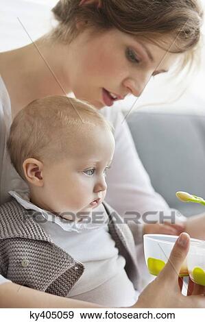 Woman feeding her daughter View Large Photo Image Stock Photo - Woman feeding her daughter. Fotosearch
