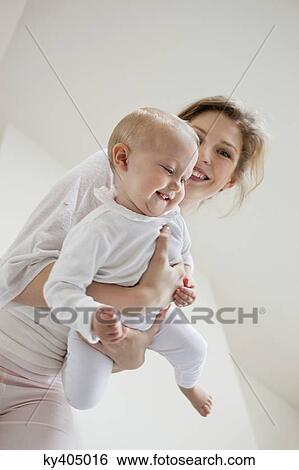 Woman playing with her daughter and smiling View Large Photo Image Stock Photograph - Woman playing with her daughter and smiling. Fotosearch