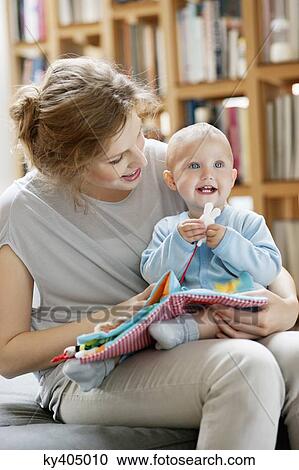 Woman reading a story to her baby from a picture book View Large Photo Image Stock Image - Woman reading a story to her baby from a picture book. Fotosearch