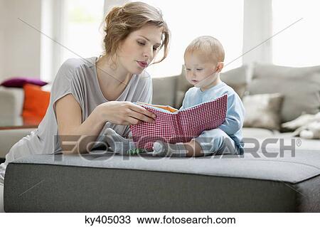 Woman showing a picture book to her daughter View Large Photo Image Stock Image - Woman showing a picture book to her daughter. Fotosearch