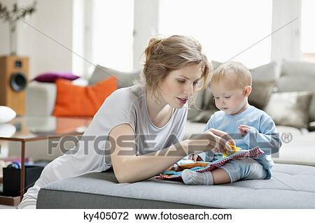 Woman showing a picture book to her daughter View Large Photo Image Stock Image - Woman showing a picture book to her daughter. Fotosearch