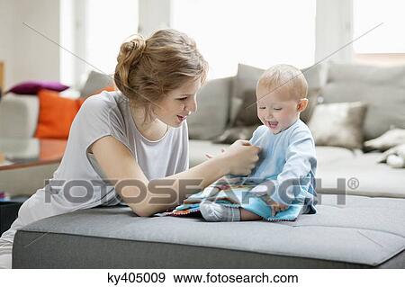 Stock Photo - Woman teaching her daughter with a picture book. Fotosearch