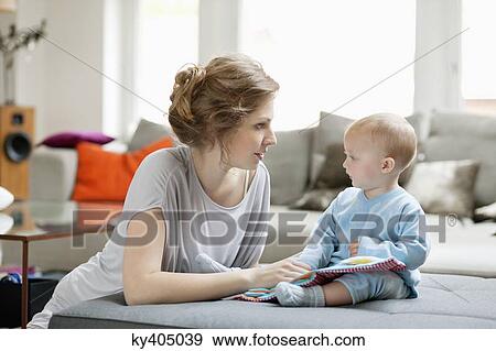Woman teaching her daughter with a picture book View Large Photo Image Stock Photo - Woman teaching her daughter with a picture book. Fotosearch