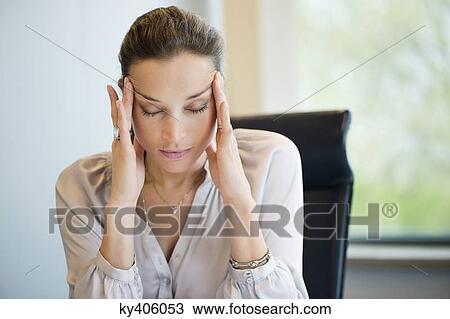 Close-up of a businesswoman suffering from a headache in an office View Large Photo Image Stock Image - Close-up of a businesswoman suffering from a headache in an office. Fotosearch
