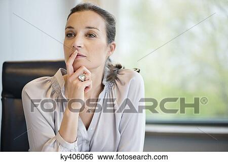 Stock Photograph - Close-up of a businesswoman thinking in an office. Fotosearch