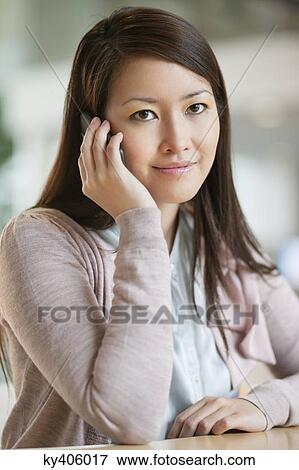 Stock Photo - Portrait of a businesswoman talking on a mobile phone in an office. Fotosearch
