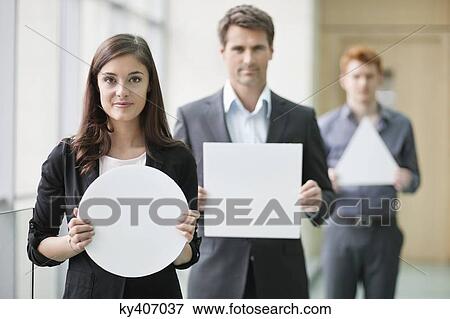 Business executives holding blank placards in an office View Large Photo Image Stock Photo - Business executives holding blank placards in an office. Fotosearch