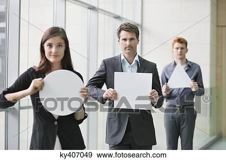 Business executives holding blank placards in an office View Large Photo Image Stock Photo - Business executives holding blank placards in an office. Fotosearch