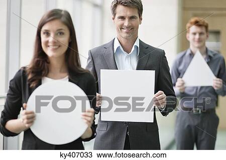Business executives holding geometrical shaped placards in an office View Large Photo Image Stock Image - Business executives holding geometrical shaped placards in an office. Fotosearch
