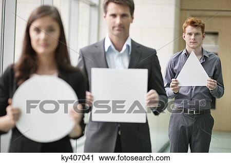 Business executives holding geometrical shaped placards in an office View Large Photo Image Stock Image - Business executives holding geometrical shaped placards in an office. Fotosearch
