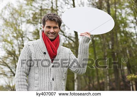 Stock Photo - Man holding a speech bubble. Fotosearch