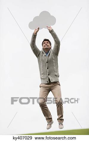 Stock Photo - Man holding a thought bubble in a field. Fotosearch
