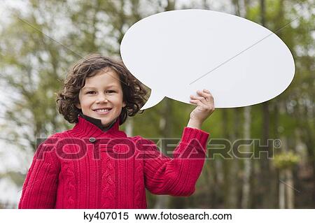 Stock Photography - Portrait of a boy holding a speech bubble. Fotosearch