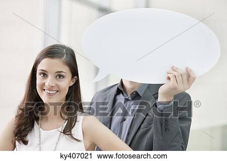 Portrait of a businesswoman smiling with her colleague holding speech bubble behind her View Large Photo Image Stock Image - Portrait of a businesswoman smiling with her colleague holding speech bubble behind her. Fotosearch