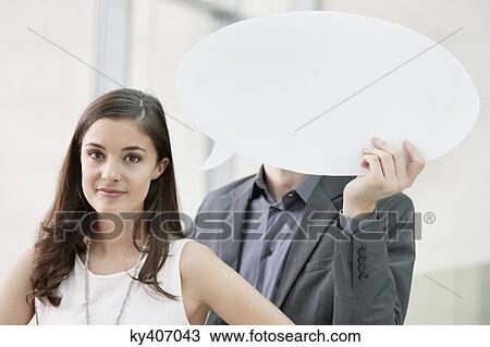 Portrait of a businesswoman with her colleague holding speech bubble in the background View Large Photo Image Stock Image - Portrait of a businesswoman with her colleague holding speech bubble in the background. Fotosearch