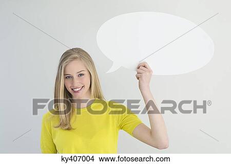 Picture - Woman holding a speech bubble and smiling. Fotosearch