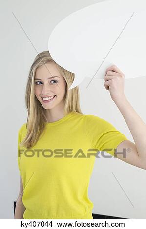 Woman holding a speech bubble and smiling View Large Photo Image Picture - Woman holding a speech bubble and smiling. Fotosearch