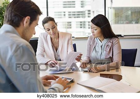 Stock Photography - Business executive discussing property documents to his clients. Fotosearch