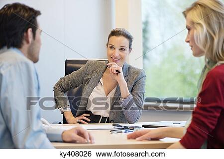 Business executive discussing with her clients View Large Photo Image Stock Photograph - Business executive discussing with her clients. Fotosearch