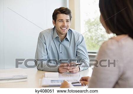 Stock Image - Business executive discussing with his client. Fotosearch