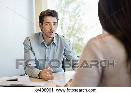 Stock Image - Business executive discussing with his client. Fotosearch