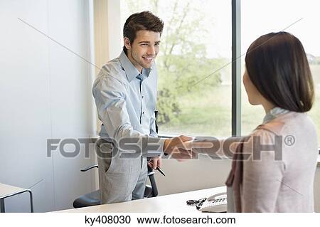 Stock Image - Business executive shaking hands with his client. Fotosearch