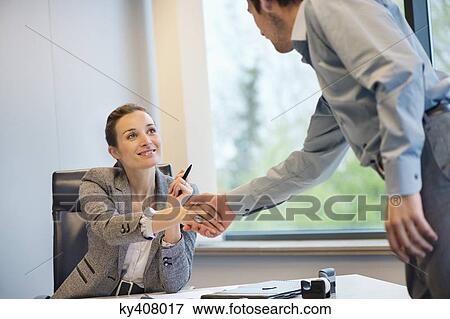Stock Photo - Business executive shaking hands with her client. Fotosearch