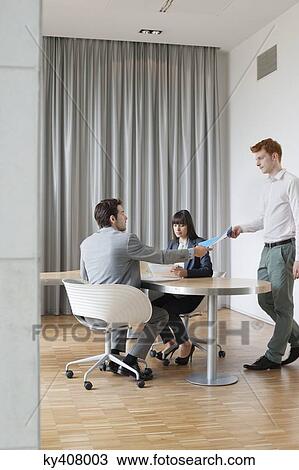 Stock Image - Business executives having a meeting in an office. Fotosearch