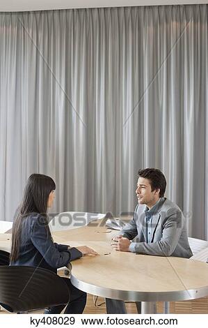 Stock Photo - Business executives having a meeting in an office. Fotosearch