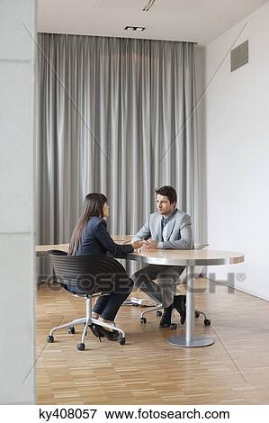 Business executives having a meeting in an office View Large Photo Image Stock Photo - Business executives having a meeting in an office. Fotosearch