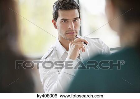 Business executives having a meeting in an office View Large Photo Image Stock Photograph - Business executives having a meeting in an office. Fotosearch