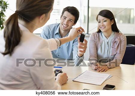 Stock Photograph - Couple receiving keys from business executive. Fotosearch