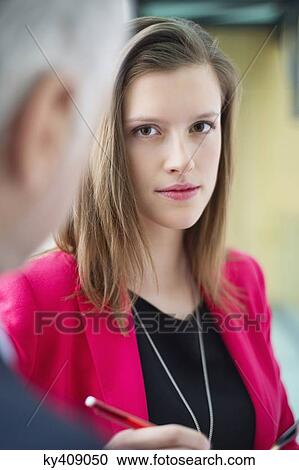Stock Image - Business executives working in an office corridor. Fotosearch