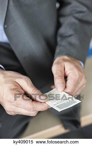 Stock Photography - Close-up of a businessman holding a business card. Fotosearch
