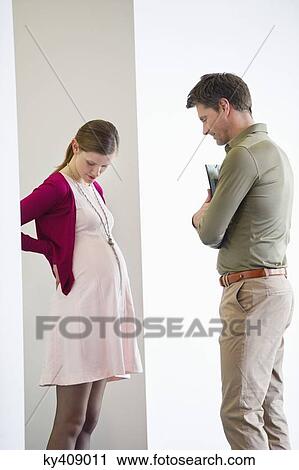 Man looking at a pregnant woman View Large Photo Image Stock Image - Man looking at a pregnant woman. Fotosearch