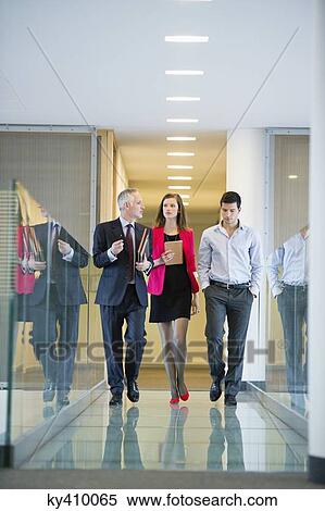 Stock Photography - Business executives discussing in an office corridor. Fotosearch