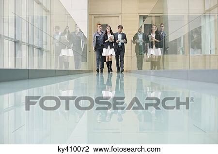 Business executives walking in a corridor View Large Photo Image Stock Image - Business executives walking in a corridor. Fotosearch