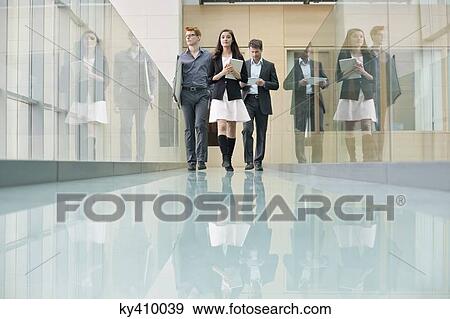 Business executives walking in a corridor View Large Photo Image Stock Photo - Business executives walking in a corridor. Fotosearch