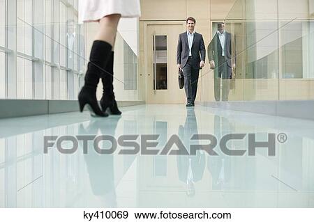 Stock Photo - Business executives walking in a corridor. Fotosearch