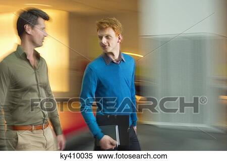 Businessmen discussing in an office corridor View Large Photo Image Stock Photography - Businessmen discussing in an office corridor. Fotosearch