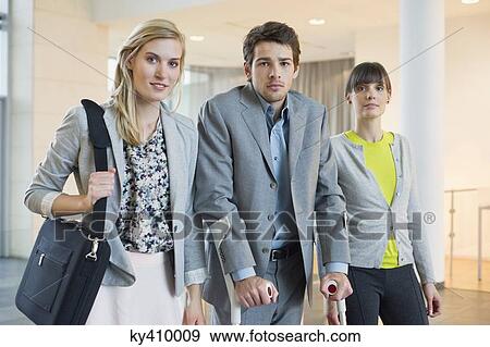 Stock Photo - Disabled businessman standing with two women. Fotosearch